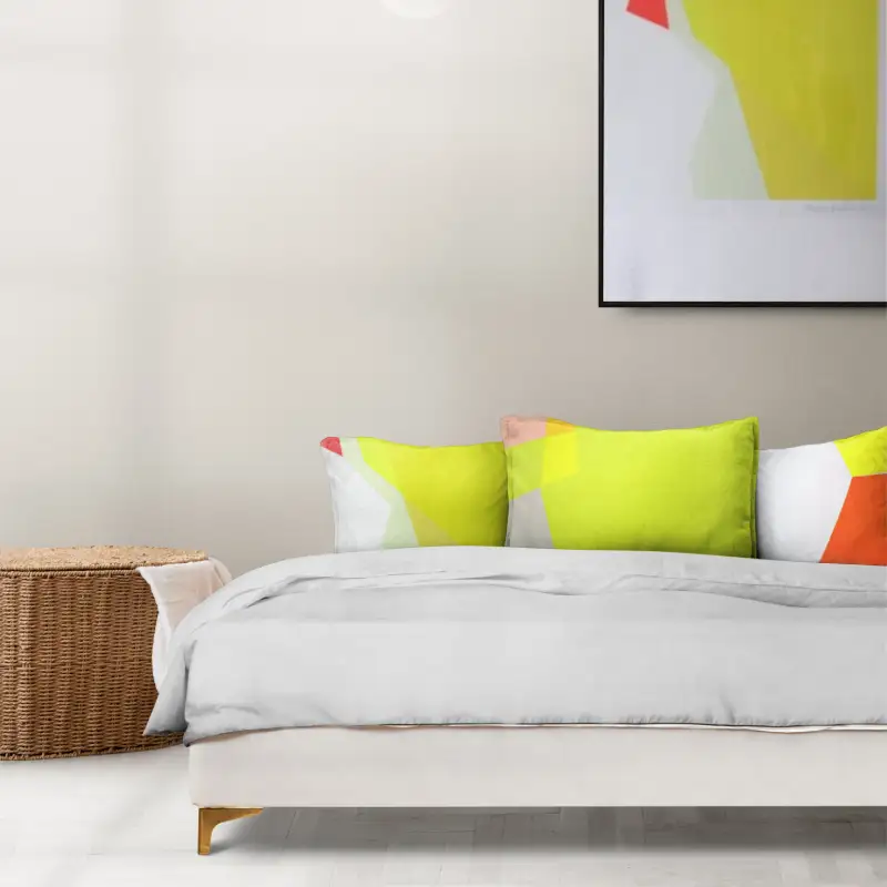 a section of the feature image which is a neutral room with a bed and bright cushions and a bright print on the wall. this is a refinned computer generated image that an interior designer might put together to show the visual of the room to a client