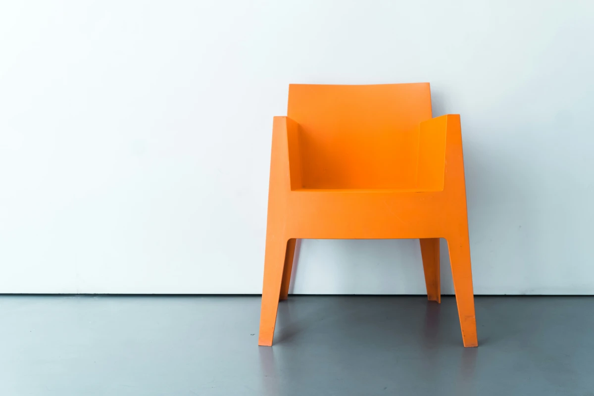 philippe starke orange outdoor chair on a neutral background